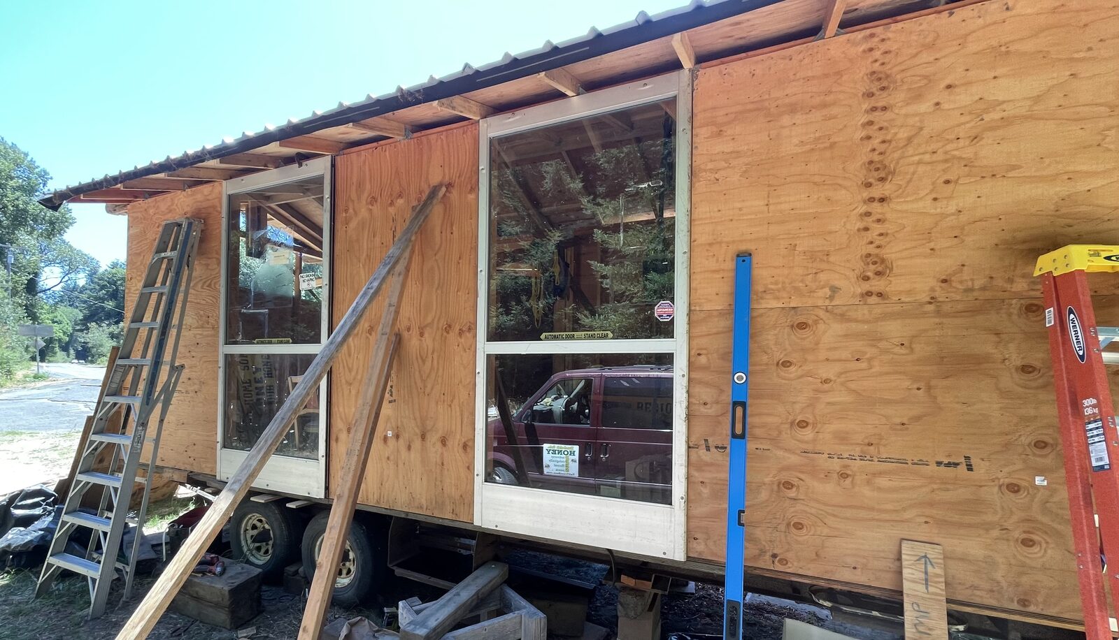 Two large four-foot glass windows installed in the plywood wall of the stand